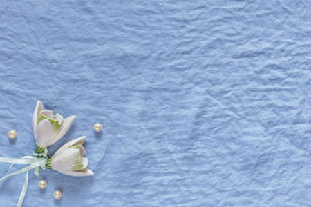 Wedding decor. White ceramic flowers, pearls on a blue fabric background. Template for wedding...