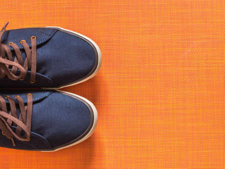 Blue sneakers on orange background