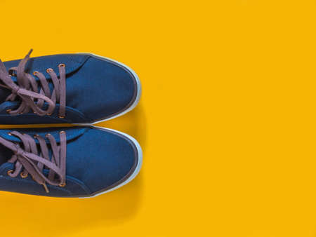 Blue sneakers on yellow background