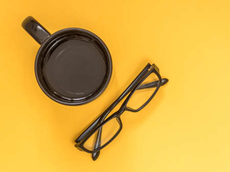 Flat lay black business accessories on yellow background with blank space for text. Top view. Copy space.の写真素材