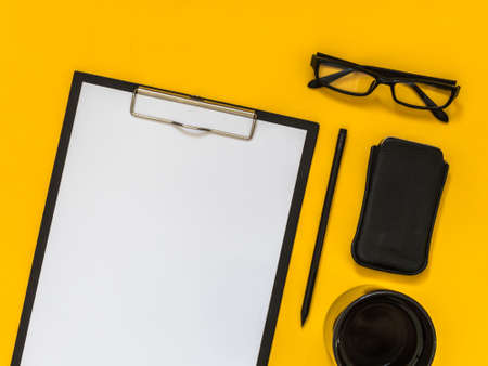 Flat lay black business accessories on yellow background with blank space for text. Top view. Copy space.の写真素材