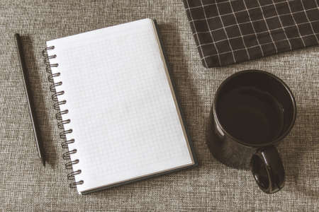 Top view goals list with notebook, cup of coffee on grey fabric. Flat lay, copy spaceの写真素材