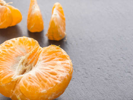 Tangerines slices on black background. Orange mandarinの写真素材