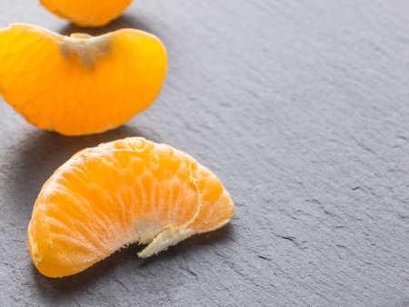 Tangerines slices on black background. Orange mandarinの写真素材