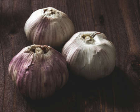 Three heads of garlic on wooden backgroundの写真素材