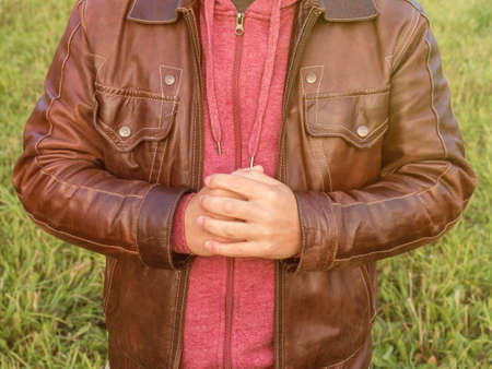 A man in a leather jacket rubbing his hands, preparing for a fight