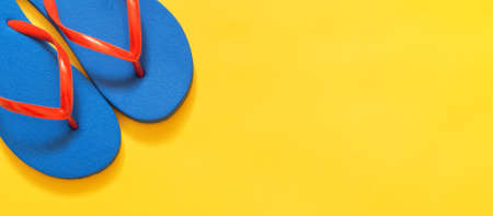 Travel vacation background. Flip flops on a yellow background. Flat layの写真素材