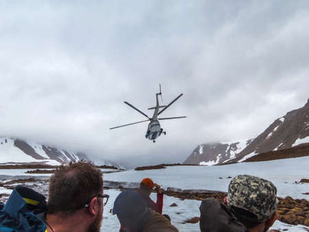 The helicopter landed tourists in the mountains. Beautiful mountain landscape, panorama. Snowy peak. Polar urals mountains. Yamalのeditorial素材