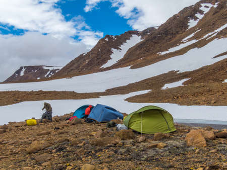 Tourist tents in the mountains. Beautiful mountain landscape, panorama. Snowy peak. Polar urals mountains. Yamalのeditorial素材