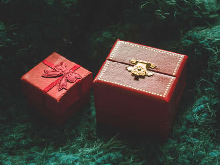 Red gift box on green soft background. Surprise, comfort, warmth, care conceptの写真素材