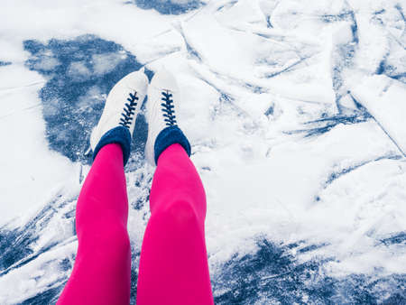 Winter holidays, weekends, fun. Beautiful female legs in bright pink tights and white ice skates. Top viewの写真素材