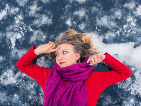 Portrait of beautiful young girl with flowing hair in red dress on blue ice background. Happiness, dreams, desires, thoughts, plans conceptの写真素材