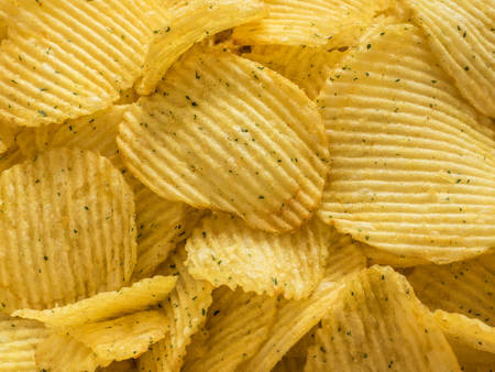 Popular american fast food, beer snack. Corrugated potato chips closeup. Texture. Background