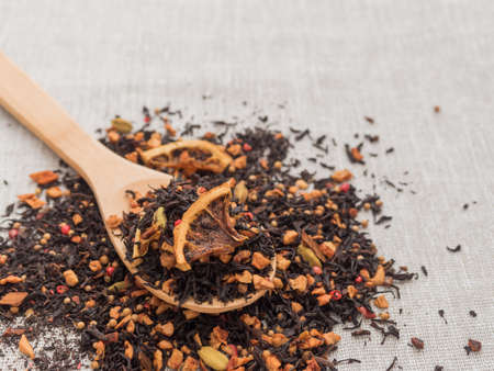 Dry leaves of black fruit tea with cinnamon, apple, orange, coriander, cardamom, cloves and red pepperの写真素材