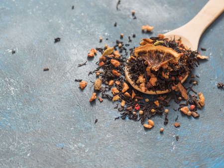 Dry leaves of black fruit tea with cinnamon, apple, orange, coriander, cardamom, cloves and red pepperの写真素材