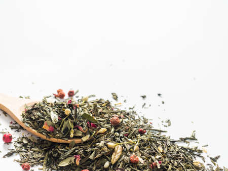 Dry leaves of Sencha green flower tea with cowberry leaf, red currant, Jasmine, rose petals, honey granules, forest berry aroma on white backgroundの写真素材