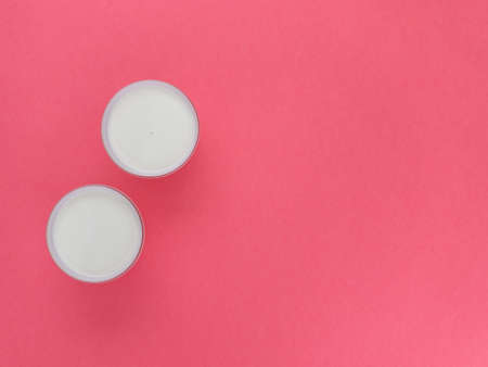Healthy breakfast. Yogurt in white glasses on pink background. Copy space, flat lay, top view