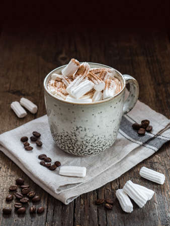 Large Ñup of coffee with milk and marshmallow sprinkled with cinnamon on a wooden tableの写真素材
