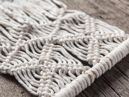 Macrame.   White thread, wooden background, closeupの写真素材