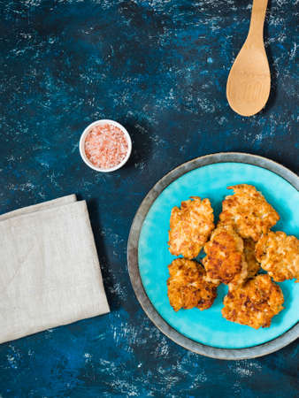 Homemade fried chicken cutlets, fillet nuggets in ceramic plate on dark blue background. Diet...