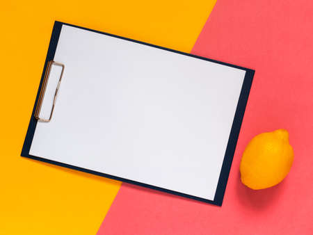 Creative geometric flat lay background. Blank clip board, yellow and pink color papper. Minimalistic...
