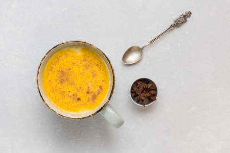 Turmeric latte with milk and cinnamon. Elixir of health and vivacity. Traditional healthy Indian...