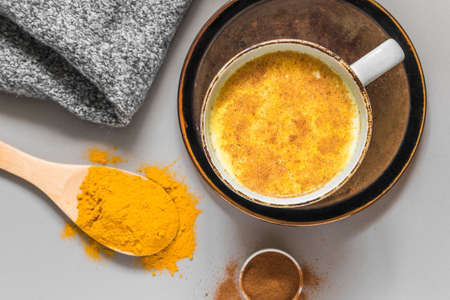 Turmeric latte with milk and cinnamon. Elixir of health and vivacity. Traditional healthy Indian...