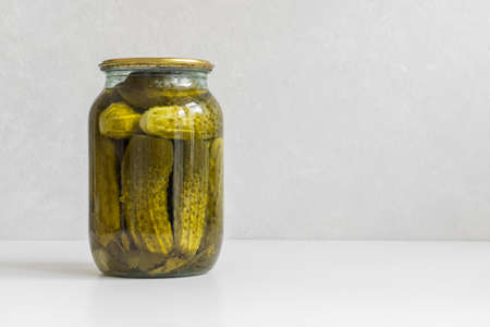 Fermented vegetables. Glass jar with homemade pickled ugly cucumbers on a white background. Copy space, close-upの写真素材