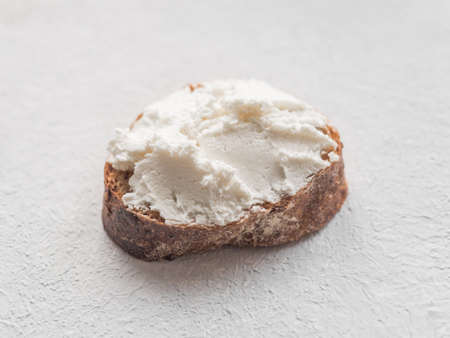 Whole grain bread bruschetta with white soft curd cream cheese on a white background. Close-up.の写真素材