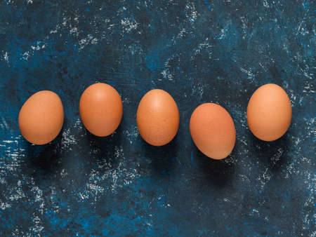 Orange chicken eggs on a dark blue background. Easter concept. Minimalism. Top view. Copy space.