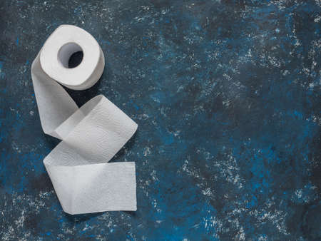 Toilet paper roll on dark blue background. Top view, copy spaceの写真素材
