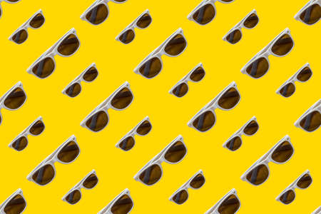 White sunglasses seamless trend pattern isolated on yellow background. Travel vacation conceptの写真素材