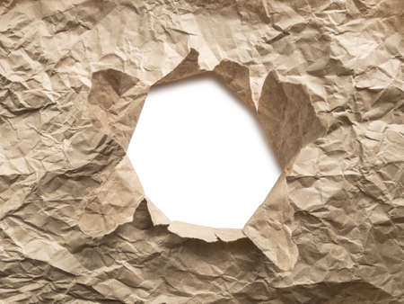 White torn hole in brown crumpled craft paper. Eco waste recycling concept.の写真素材