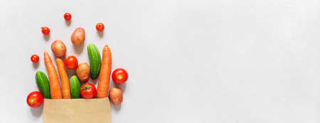 Fresh farm vegetarian and vegan vegetables in paper bag on white background. Healthy food supermarket banner. Zero waste concept. Copy spaceの写真素材