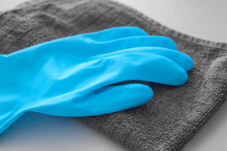 Cleaning and disinfection concept. Close-up blue rubber glove on gray antibacterial disinfectant napkin.の写真素材