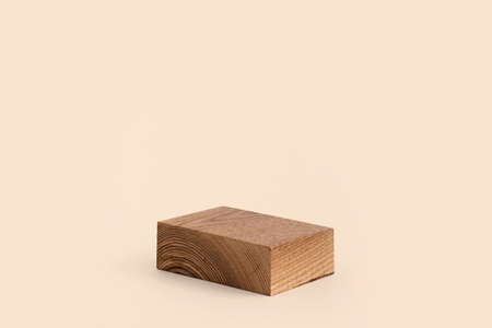 Minimal rectangular wooden geometric podium. Wooden saw cut rectangular shape on beige background. Scene with geometrical forms. Empty showcase for product presentationの写真素材