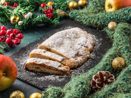 Stollen. Traditional German Christmas cupcake with nuts and dried fruits. Sweet New Year holiday cake on dark backgroundの写真素材