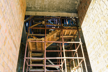 Constructions on the building under construction. Iron lessa and wooden stairs. Construction of the...