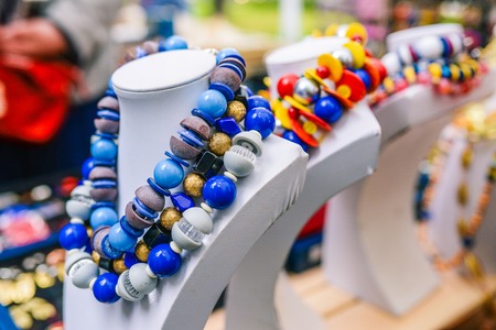Big beads on a mannequin. Bright feminine decoration in blue and white. Selling colorful necklaces on the counterの写真素材