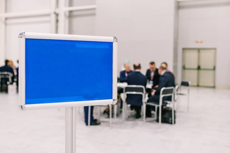 A group of people are discussing a project. Men negotiate at the table. Empty blue plate. Meeting staffの写真素材