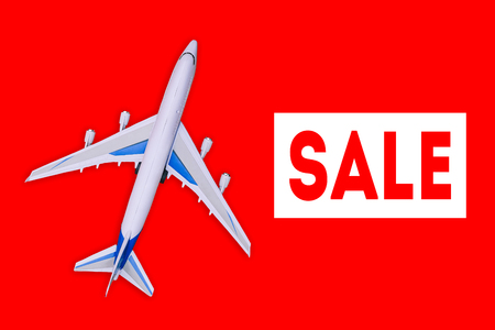 Passenger aircraft on a red background. Sale of air tickets and travel vouchers. Advertising banner and discount. Travel and tourism conceptの写真素材