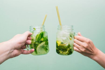 Woman and man drinking a cocktail. Friends relax at a party or club, celebrate and relax, holding fruit drinks in their hands. Young people fry cocktailsの写真素材