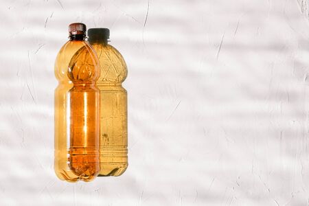 Empty bottle on white background. From the bottle falls hard shadow. Bright sun shines. Ecology concept, land pollution or bottle production. Copy space.の写真素材