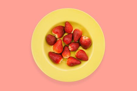 Yellow plate with strawberries on a bright background. Ripe strawberries, red color in a yellow plate. Healthy food, a source of vitamins. Use in medicineの写真素材