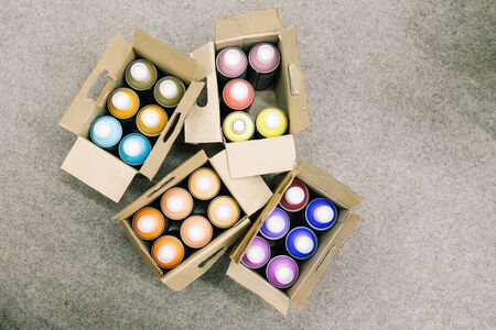 Set of aerosols with paint of different colors for painting walls and graffiti in a cardboard box. Spray paint dispenser in various colors.の写真素材