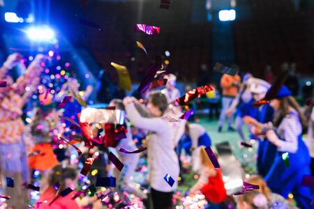Festive blurred background. People have fun at the party. Confetti shot.