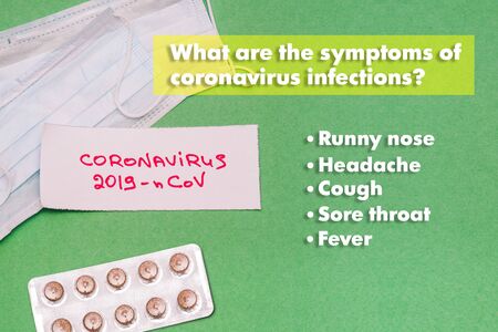 Symptoms of the new 2019-nCoV coronovirus. Respiratory masks and medicines on a green background. A...