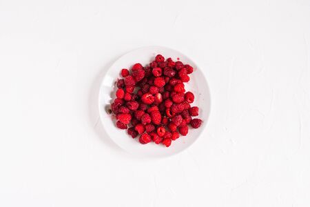 White plate with raspberries. Fresh raspberries isolated on white backgroundの写真素材