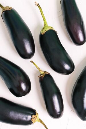 Raw ripe eggplant on a light background, top view. Fresh vegetables for cookingの写真素材