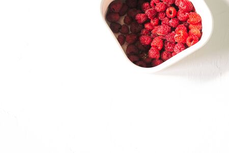 White box with raspberries. Raspberries on an isolated background with copy spaceの写真素材
